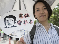 Worker holds placard during the May Day rally sponsored by the Japanese Trade Union Confederation, known as Rengo at Yoyogi Park in Shibuya...