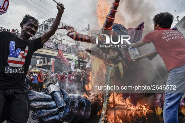 Workers burn an effigy of President Rodrigo Duterte as they take part in labor day demonstrations outside the presidential palace in Manila,...