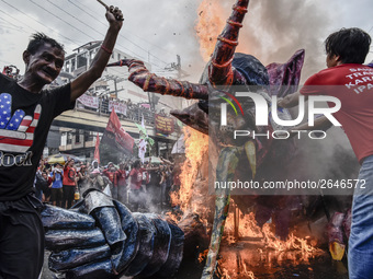 Workers burn an effigy of President Rodrigo Duterte as they take part in labor day demonstrations outside the presidential palace in Manila,...