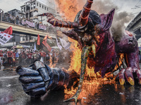 Workers burn an effigy of President Rodrigo Duterte as they take part in labor day demonstrations outside the presidential palace in Manila,...