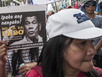 A worker holds a placard with President Rodrigo Duterte's portrait during labor day demonstrations outside the presidential palace in Manila...