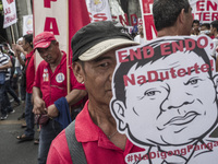 A worker holds a placard with President Rodrigo Duterte's portrait during labor day demonstrations outside the presidential palace in Manila...