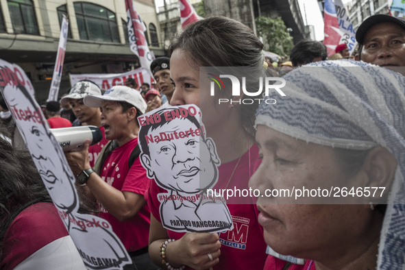 Workers hold placards with President Rodrigo Duterte's portrait during labor day demonstrations outside the presidential palace in Manila, P...