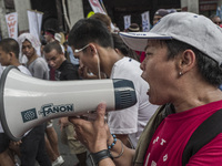 A workers shouts slogans over a speakerphone during labor day demonstrations outside the presidential palace in Manila, Philippines, May 1,...