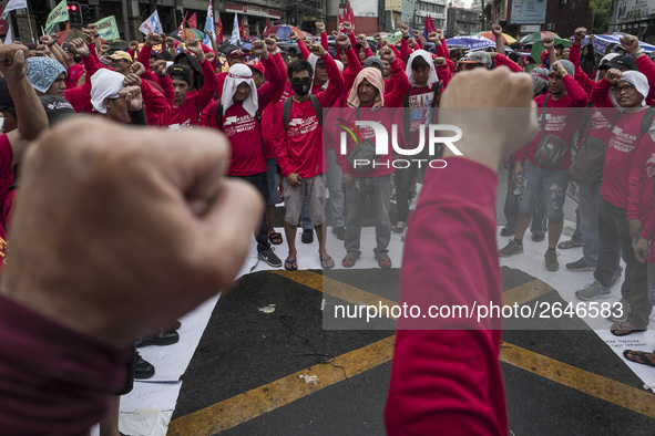 Workers raise their fists during labor day demonstrations outside the presidential palace in Manila, Philippines, May 1, 2018. Thousands of...