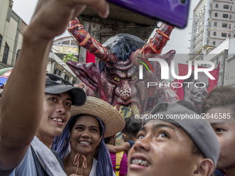 Workers take a selfie with an effigy of President Rodrigo Duterte during labor day demonstrations outside the presidential palace in Manila,...