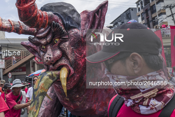 A worker helps move an effigy of President Rodrigo Duterte as he takes part in labor day demonstrations outside the presidential palace in M...