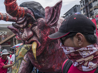 A worker helps move an effigy of President Rodrigo Duterte as he takes part in labor day demonstrations outside the presidential palace in M...