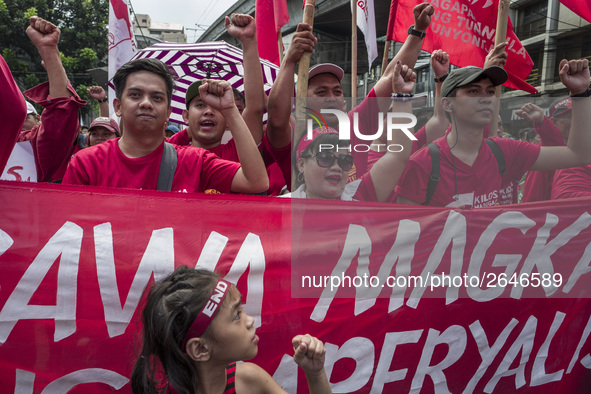 Workers raise their fists as they shout slogans during labor day demonstrations outside the presidential palace in Manila, Philippines, May...