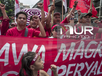 Workers raise their fists as they shout slogans during labor day demonstrations outside the presidential palace in Manila, Philippines, May...