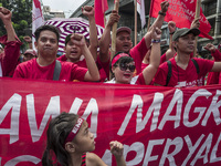 Workers raise their fists as they shout slogans during labor day demonstrations outside the presidential palace in Manila, Philippines, May...