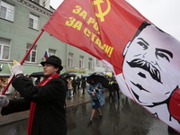 A supporter of the Communist party with a flag with a portrait of Stalin during the may day demonstration in St Petersburg, Russia. 1 may 20...