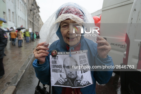 A supporter of the Communist party's poster against Vladimir Putin during a may day demonstration in St Petersburg, Russia. 1 may 2018 