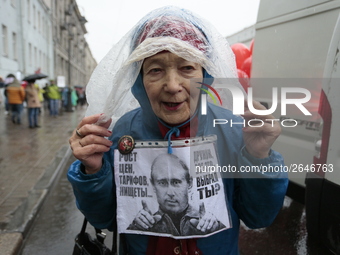 A supporter of the Communist party's poster against Vladimir Putin during a may day demonstration in St Petersburg, Russia. 1 may 2018 (