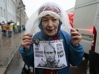 A supporter of the Communist party's poster against Vladimir Putin during a may day demonstration in St Petersburg, Russia. 1 may 2018 (