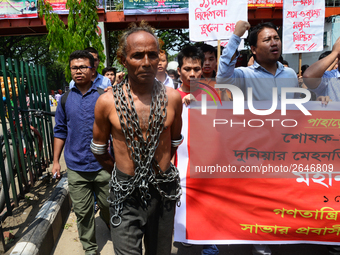 A Bangladeshi worker wears metal chain as he attends a May Day protest rally in Dhaka, Bangladesh on May 01, 2018. Thousands of workers of s...