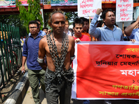 A Bangladeshi worker wears metal chain as he attends a May Day protest rally in Dhaka, Bangladesh on May 01, 2018. Thousands of workers of s...