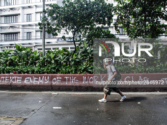 A man walks past a spray-painted slogan saying "Duterte Enemy of the Working Class" after Labor Day Protest ended. Activists gather in Mendi...