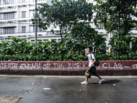 A man walks past a spray-painted slogan saying "Duterte Enemy of the Working Class" after Labor Day Protest ended. Activists gather in Mendi...