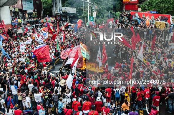 Protesters watch the effigy of President Rodrigo Duterte burn. Thousands of activists attend the Labor Day Protest in Mendiola street, Manil...