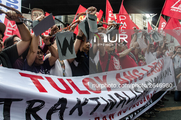 Activists hold a banner and a chain as they urge the President Duterte end contractualization during the Labor Day protest in Mendiola stree...