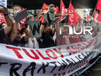 Activists hold a banner and a chain as they urge the President Duterte end contractualization during the Labor Day protest in Mendiola stree...