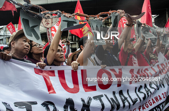 Activists hold a banner and a chain as they urge the President Duterte end contractualization during the Labor Day protest in Mendiola stree...