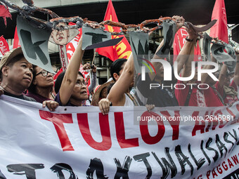 Activists hold a banner and a chain as they urge the President Duterte end contractualization during the Labor Day protest in Mendiola stree...