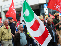 Man with a flag of the Italian governing party Partito Democratico (PD). Several thousands followed the invitation of the trade unions such...