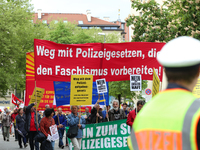 Protestors carry banners against the new Poliziaufgabengesetz of the CSU party as a policeman looks at them. Several thousands followed the...