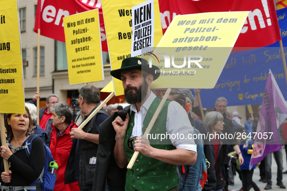 A man with traditional Bavarian clothing has a sign against the Polizeiaufgabengesetz. Several thousands followed the invitation of the trad...