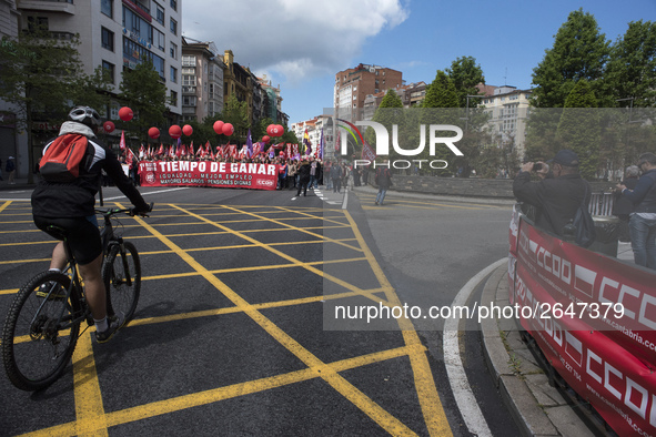 A cyclist passes in front of the demonstration to celebrate the international day of work called by the unions and that runs through the str...