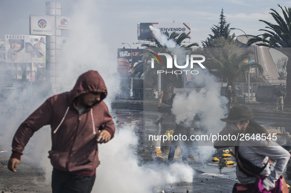 Demonstrators clash with riot police following a May Day march in Santiago on May 1, 2018.  The clashes between demonstrators and carabinero...