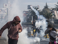 Demonstrators clash with riot police following a May Day march in Santiago on May 1, 2018.  The clashes between demonstrators and carabinero...