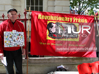 Protester with Communist flag at Mayday . International Workers Day in London kicked off with a march through Central London and ended in Tr...