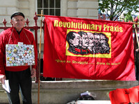 Protester with Communist flag at Mayday . International Workers Day in London kicked off with a march through Central London and ended in Tr...