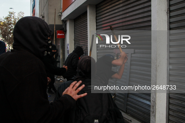 Demonstrators clash with riot police following a May Day march in Santiago on May 1, 2018. ( 