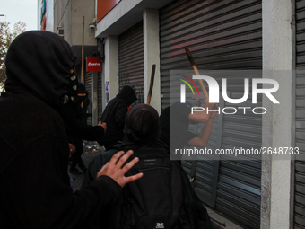 Demonstrators clash with riot police following a May Day march in Santiago on May 1, 2018. ( (