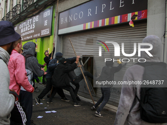 Demonstrators clash with riot police following a May Day march in Santiago on May 1, 2018. ( (