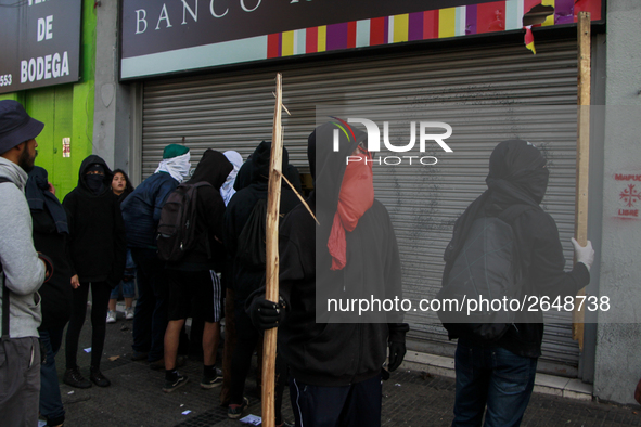 Demonstrators clash with riot police following a May Day march in Santiago on May 1, 2018. (. 