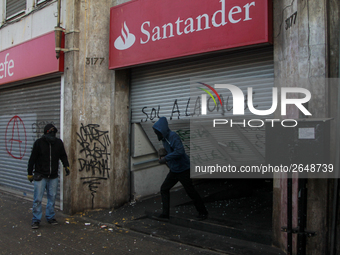 Demonstrators clash with riot police following a May Day march in Santiago on May 1, 2018. ( (