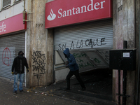 Demonstrators clash with riot police following a May Day march in Santiago on May 1, 2018. ( (