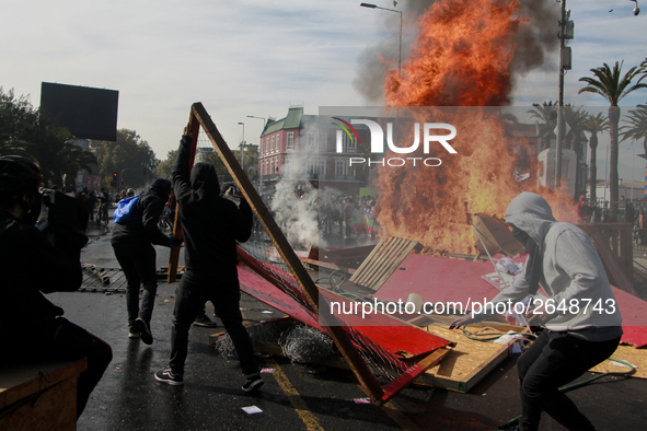 Demonstrators clash with riot police following a May Day march in Santiago on May 1, 2018. ( 