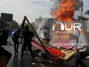 Demonstrators clash with riot police following a May Day march in Santiago on May 1, 2018. ( (