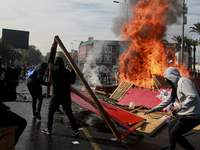 Demonstrators clash with riot police following a May Day march in Santiago on May 1, 2018. ( (