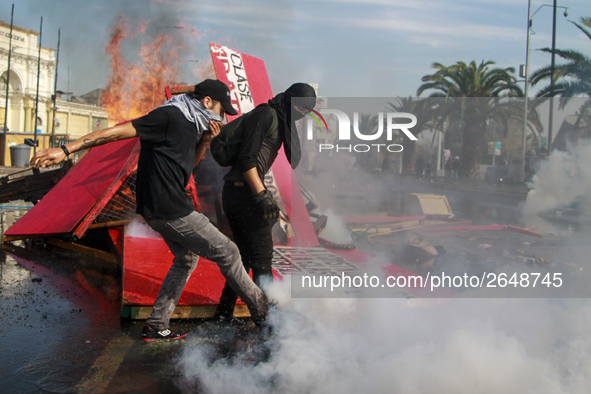 Demonstrators clash with riot police following a May Day march in Santiago on May 1, 2018. ( 