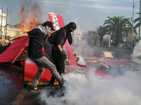 Demonstrators clash with riot police following a May Day march in Santiago on May 1, 2018. ( (