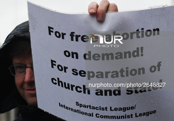 Member of Spartacist League holds 'For free abortion on demande! For separation of church and state!' sign as he joins hundreds of people in...