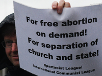 Member of Spartacist League holds 'For free abortion on demande! For separation of church and state!' sign as he joins hundreds of people in...