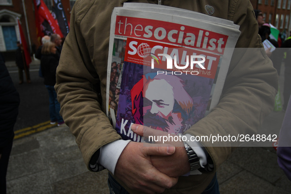 A member of the Socialist Party holds a latest Socialist Alternative paper, as Hundreds of people including SIPTU unions, Right2Work campaig...